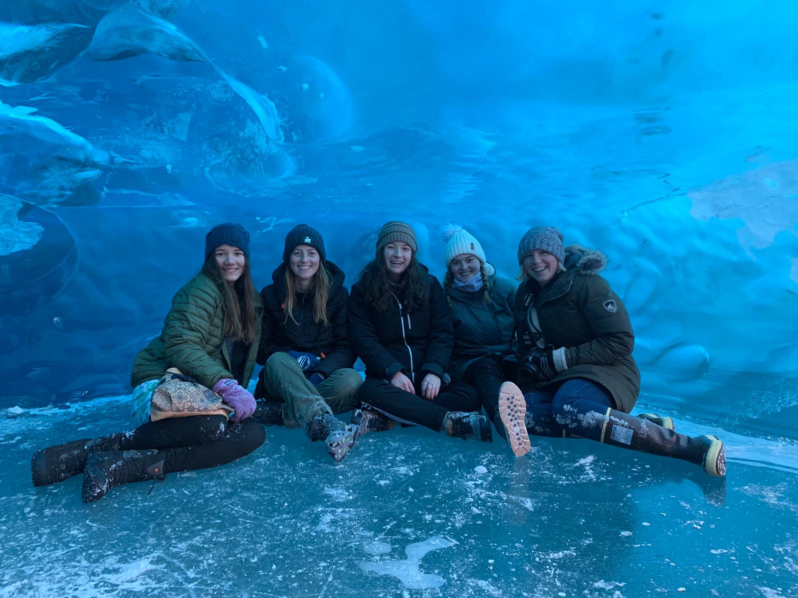 a group sitting inside of a glacier