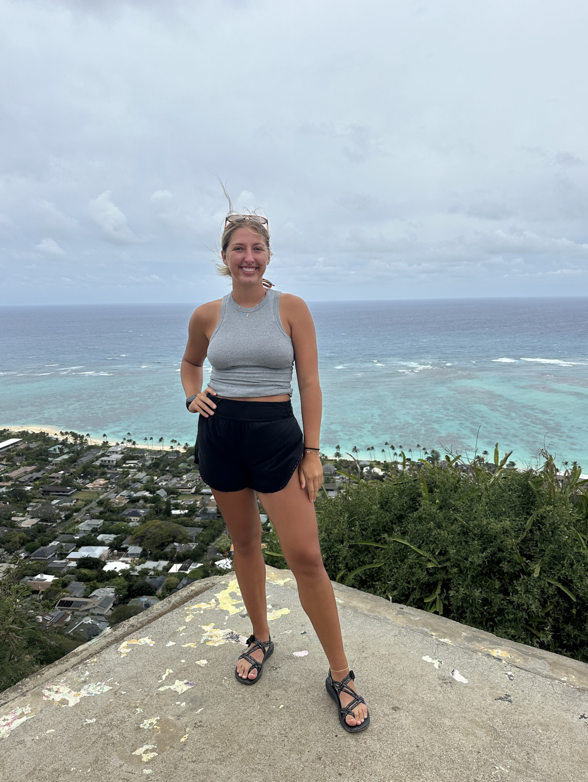 Image shows a student posing in front of an ocean scene