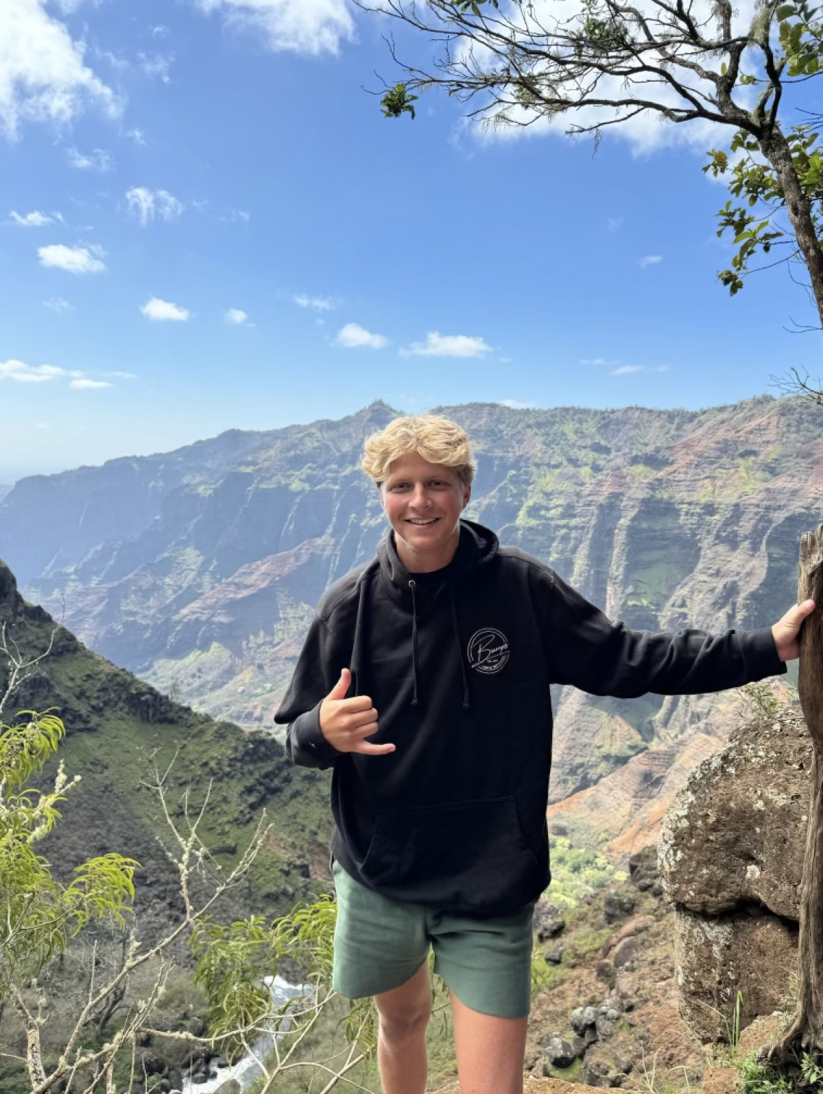 Image shows a male student with a mountainous scene behind